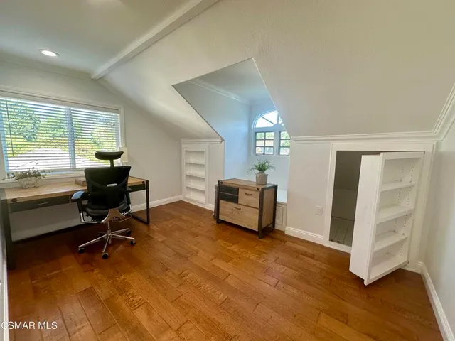 a view of a livingroom with workspace and a window