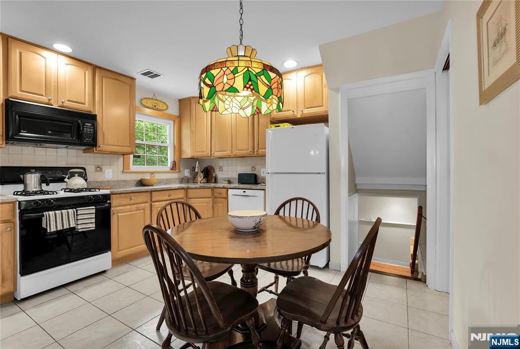 23 Ridge Court Cedar Grove, NJ 07009 - Photo 14 of 37 a kitchen with stainless steel appliances granite countertop a dining table chairs and a refrigerator