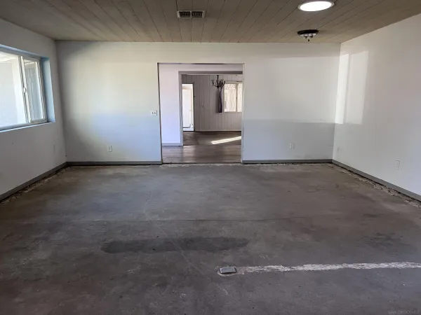 a view of pool with outdoor seating and covered with trees