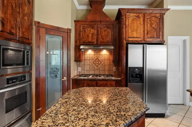 a kitchen with a refrigerator and a stove top oven