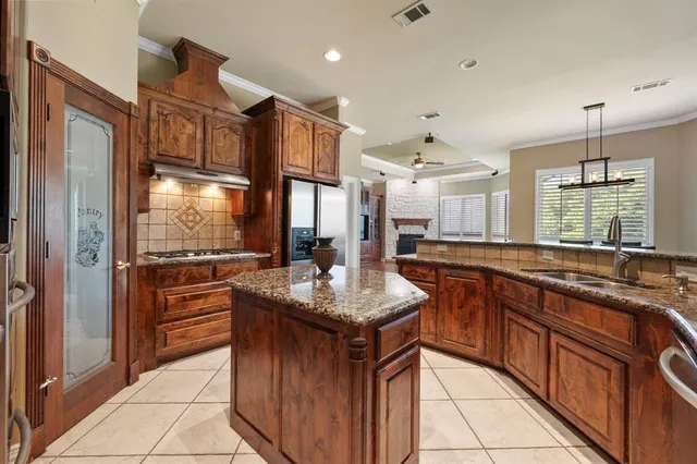 a kitchen with stainless steel appliances granite countertop a stove a sink dishwasher and a refrigerator