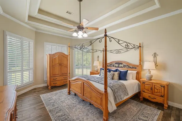 a bedroom with a bed a chandelier and dresser