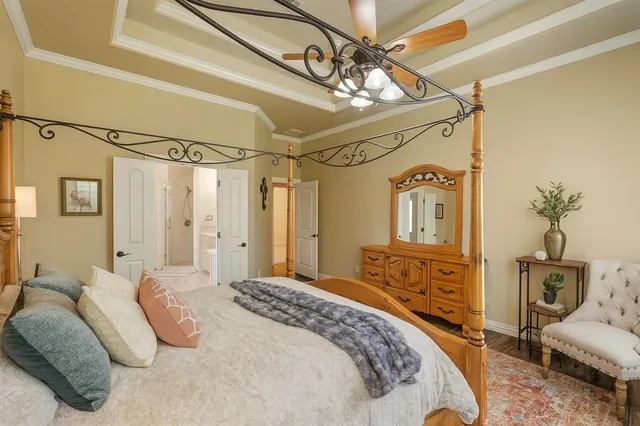 a bedroom with a bed a chandelier and dresser