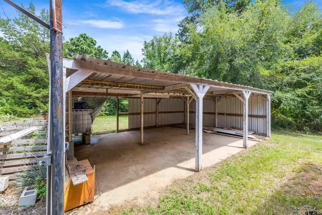 a backyard of a house with table and chairs a barbeque with wooden fence