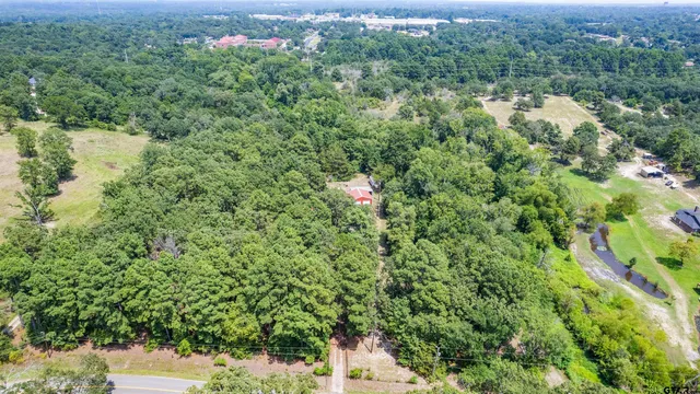 an aerial view of residential house with outdoor space and trees all around