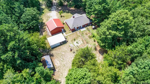 an aerial view of house with yard and swimming pool