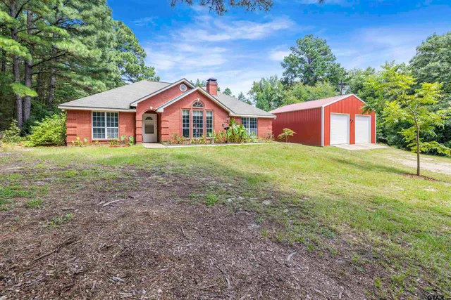 a front view of a house with a yard and trees
