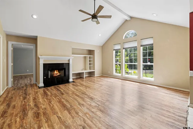 a view of empty room with wooden floor and fireplace