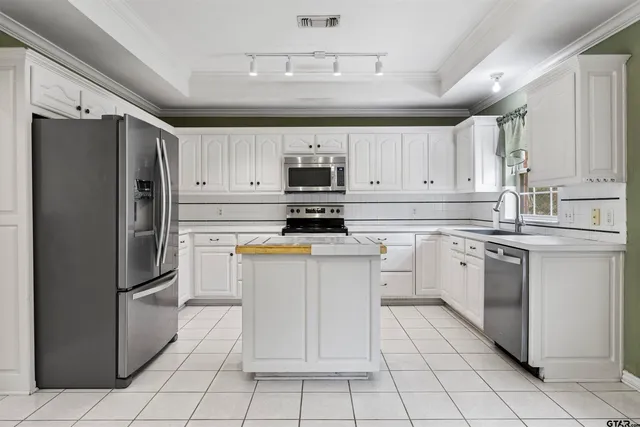 a kitchen with cabinets stainless steel appliances and a counter space