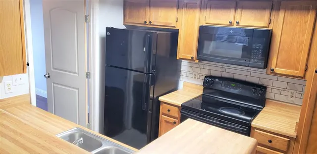 a kitchen with a refrigerator and a stove