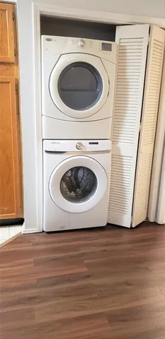 a utility room with wooden floor washer and dryer