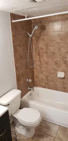 a white toilet sitting next to a bath tub and a shower