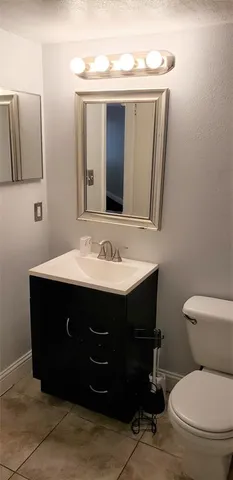 a bathroom with a sink vanity mirror and toilet