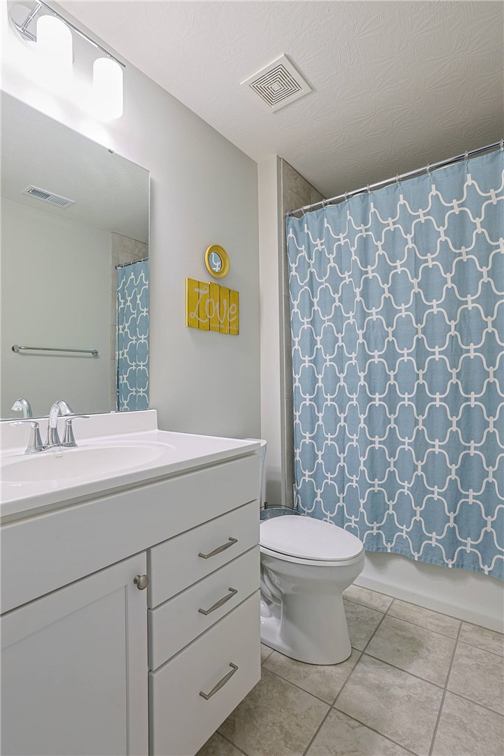5013 Arena Court Hamilton, OH 45011 - Photo 30 of 41 This bright bathroom features a vanity, toilet, and a tiled floor, creating a clean and functional space.