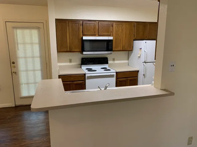 a kitchen with stainless steel appliances a stove microwave and refrigerator