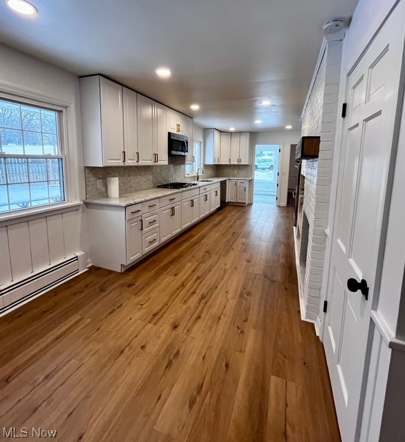 305 Tremont Road Akron, OH 44313 - Photo 7 of 25 Kitchen with tasteful backsplash, white cabinets, gas stovetop, and hardwood / wood-style flooring