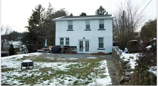 a view of a house with yard and covered with snow in the background
