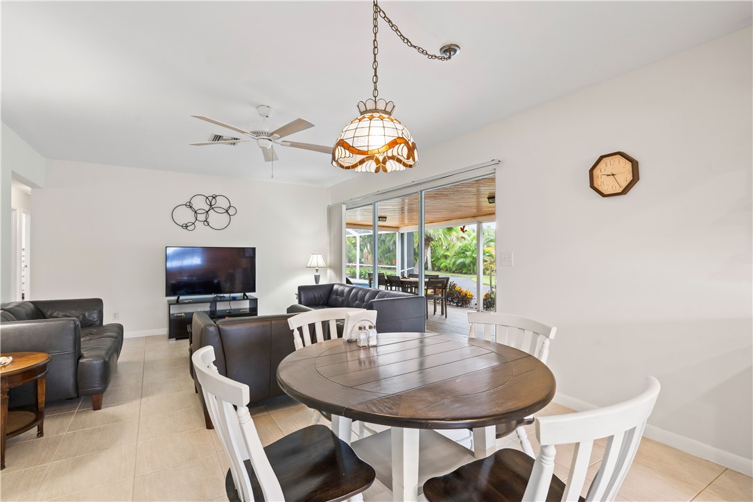 618 Conn Way Vero Beach, FL 32963 - Photo 11 of 36 a dining room with wooden floor a chandelier a wooden table and chairs