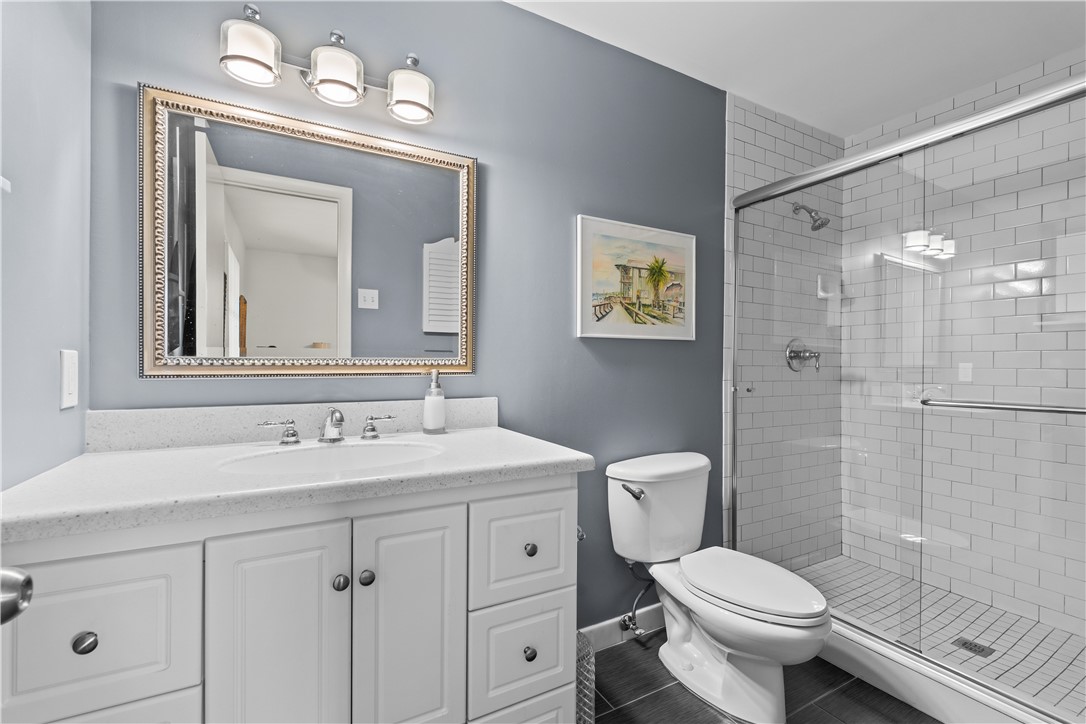 618 Conn Way Vero Beach, FL 32963 - Photo 19 of 36 a bathroom with a toilet a sink a glass door a shower a mirror and vanity