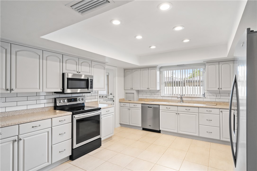 618 Conn Way Vero Beach, FL 32963 - Photo 3 of 36 a kitchen with white cabinets stainless steel appliances and sink