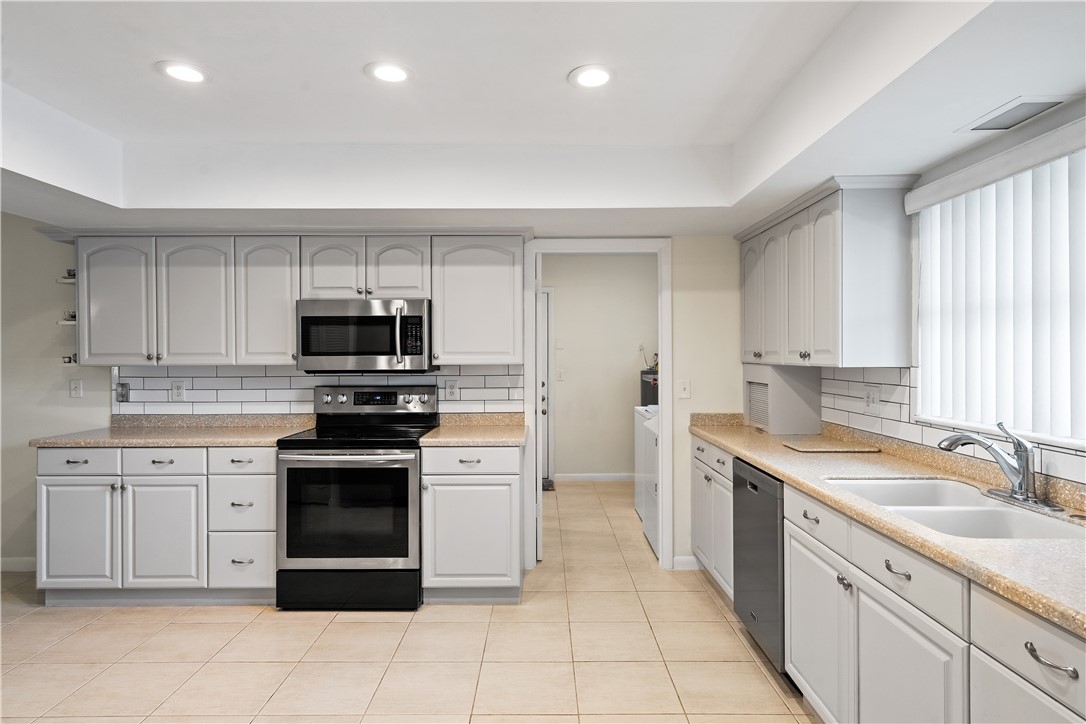 618 Conn Way Vero Beach, FL 32963 - Photo 8 of 36 a kitchen with stainless steel appliances granite countertop a sink and dishwasher a stove top oven with white cabinets