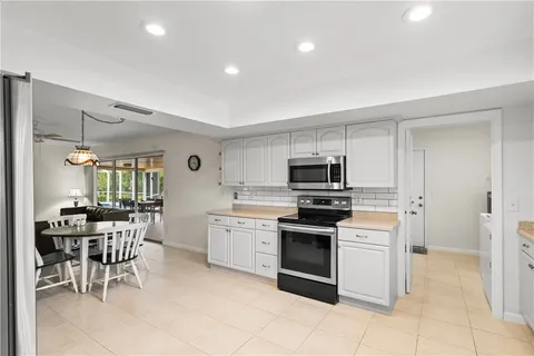 a kitchen with stainless steel appliances granite countertop a stove top oven a sink dishwasher and a refrigerator