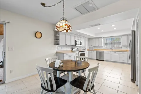 a view of kitchen and dining area with a sink