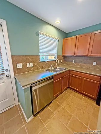 a kitchen with a sink a stove cabinets and a counter top space