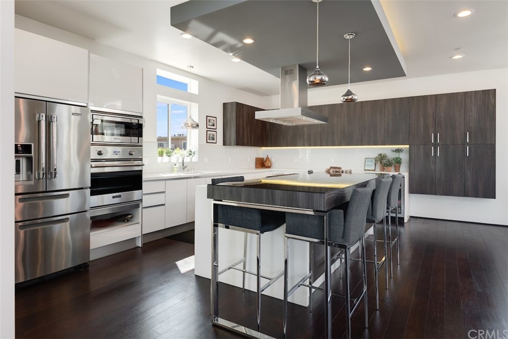 203 South Prospect Avenue, Unit A Redondo Beach, CA 90277 - Photo 6 of 39 a kitchen with stainless steel appliances kitchen island granite countertop a table chairs and a refrigerator
