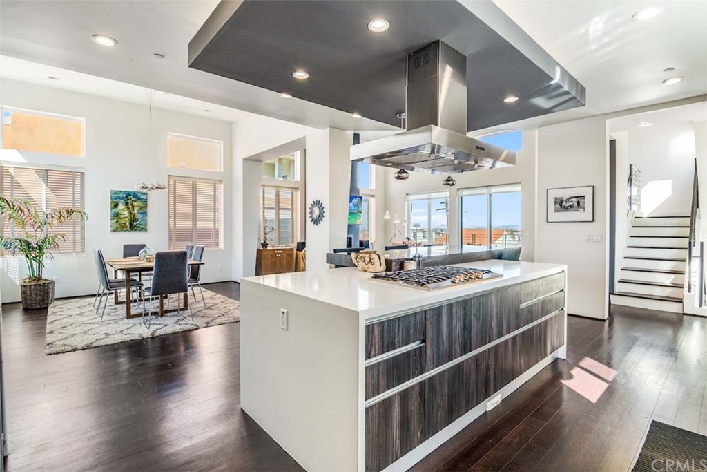 203 South Prospect Avenue, Unit A Redondo Beach, CA 90277 - Photo 8 of 39 a kitchen with stainless steel appliances a stove a sink dishwasher and a dining table with wooden floor
