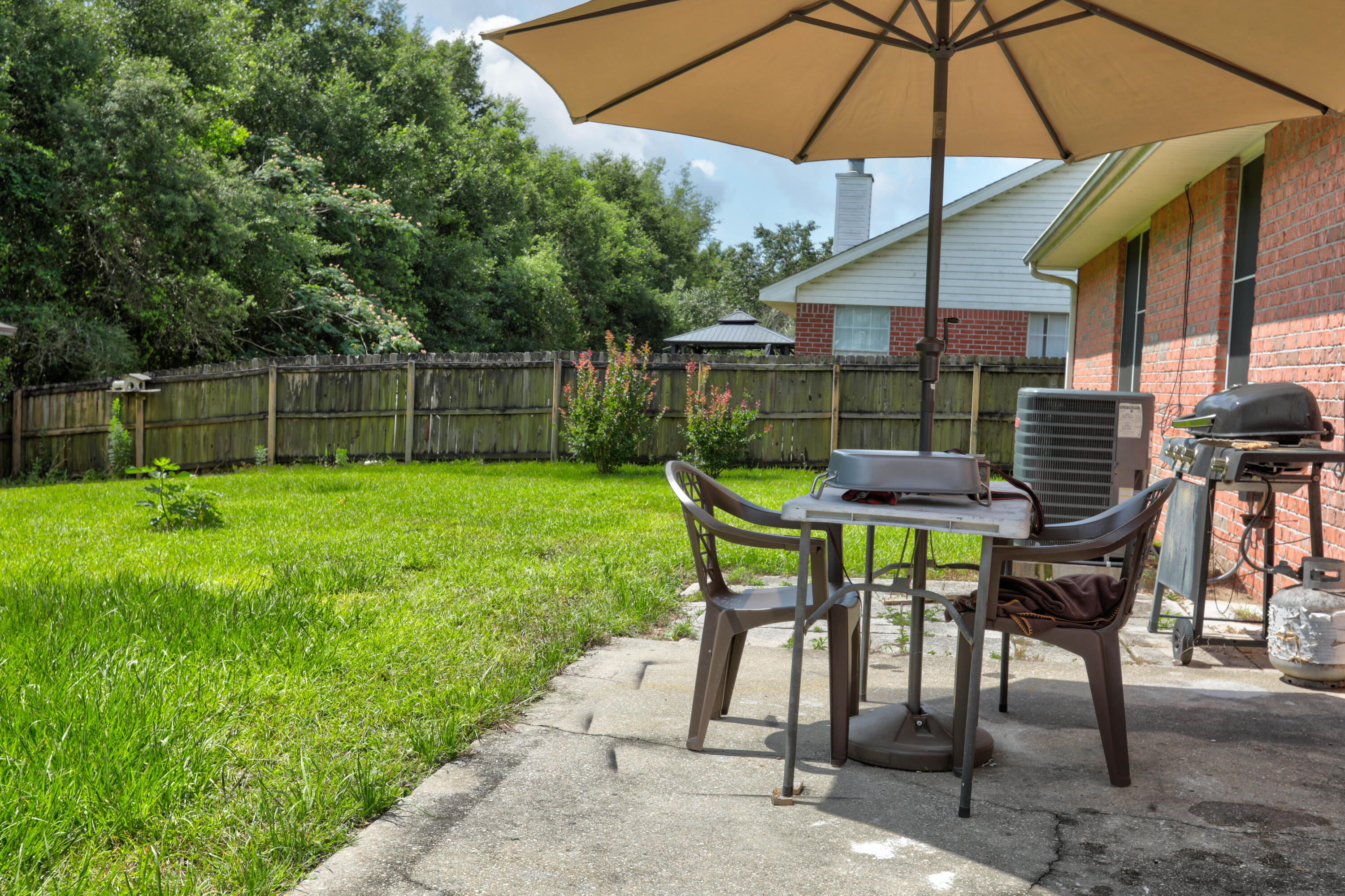 6803 Cedar Ridge Circle Milton, FL 32570 - Photo 7 of 26 a view of patio with table and chairs under an umbrella