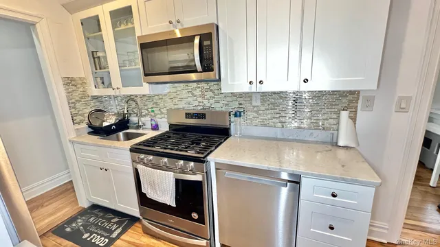 a kitchen with white cabinets and appliances