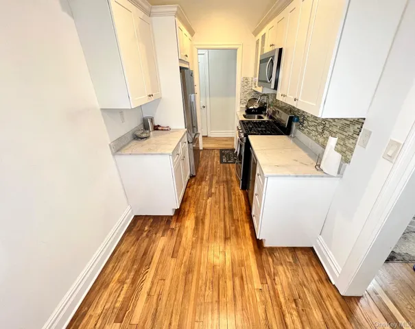 a view of a kitchen with a sink and wooden floor