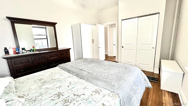a bed room with a bed mirror and a dresser