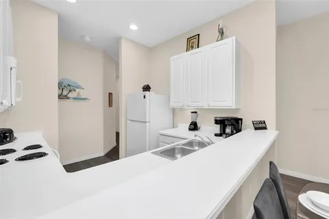 a kitchen with a sink a stove and white cabinets
