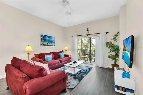 a living room with furniture a flat screen tv and a large window