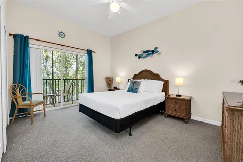 a bedroom with a bed chair and a large window