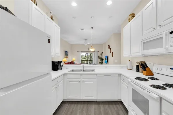 a kitchen with white cabinets sink and white appliances