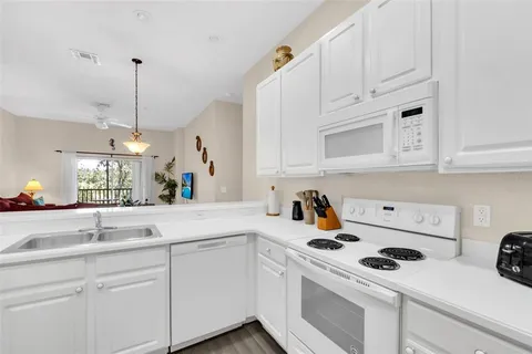a kitchen with white cabinets and white appliances