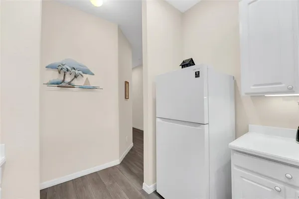 a walk in closet with wooden floor