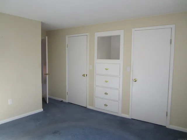 an empty room with closet and mirror