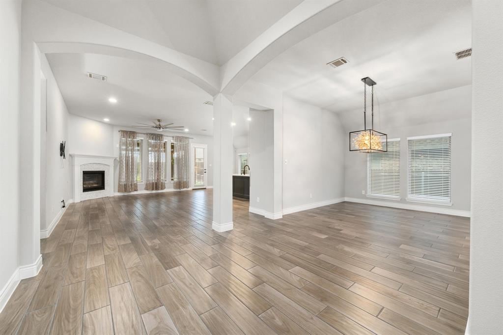 1501 Calcot Lane Forney, TX 75126 - Photo 9 of 34 Expansive interior featuring wood-finish flooring, arched doorways, recessed lighting, and a modern rectangular chandelier
