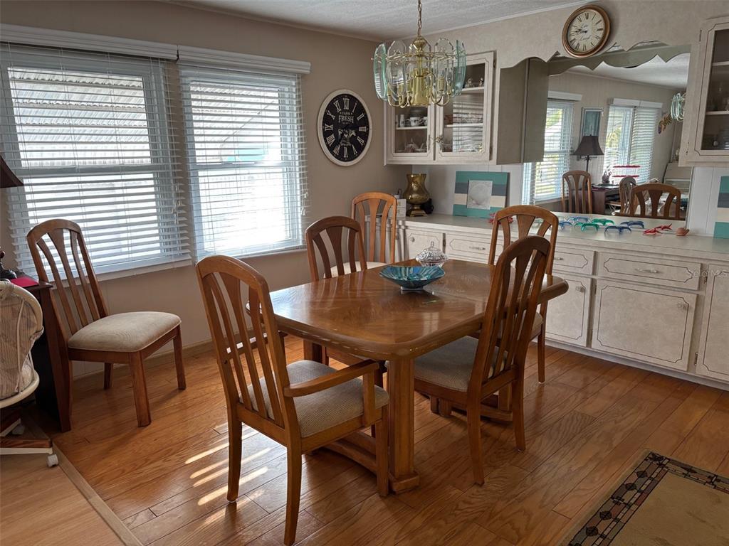 709 Sugar Palm Street Largo, FL 33778 - Photo 12 of 34 a view of a dining room with furniture a chandelier and wooden floor