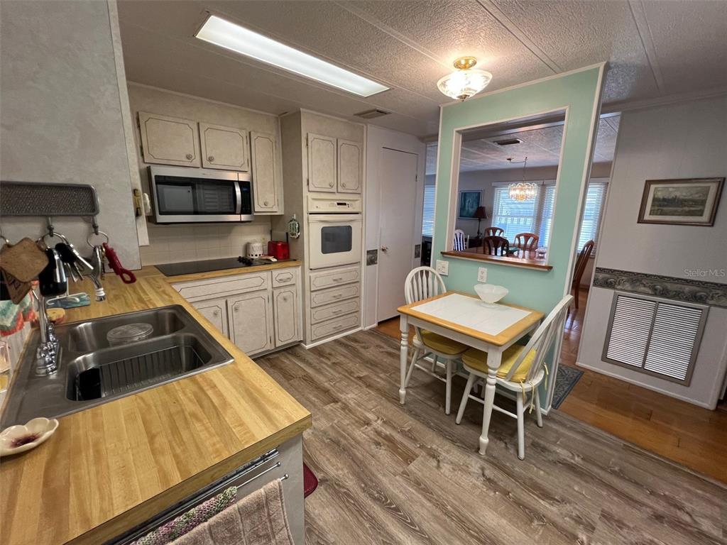 709 Sugar Palm Street Largo, FL 33778 - Photo 9 of 34 a kitchen with a table chairs microwave and cabinets
