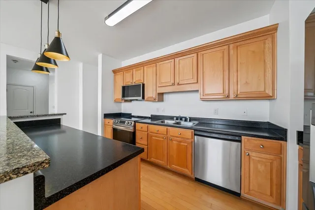 a kitchen with stainless steel appliances granite countertop a sink a stove and cabinets