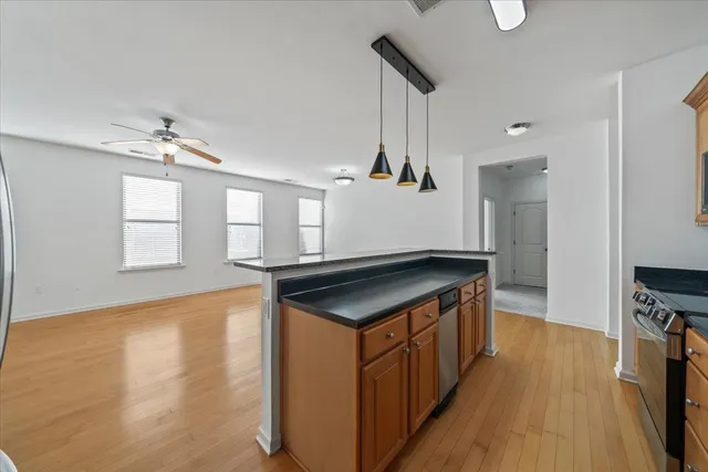 a kitchen with stainless steel appliances granite countertop a sink stove and wooden floor