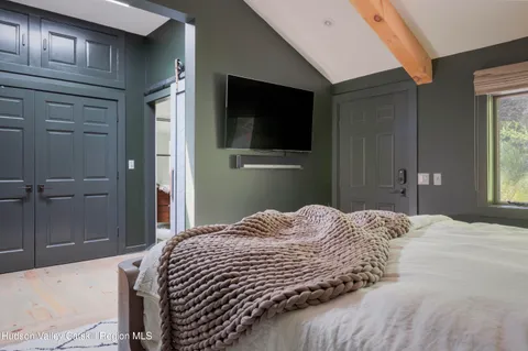 a bedroom with a bed and a flat screen tv