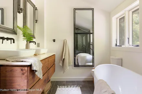 a bathroom with a tub sink and mirror