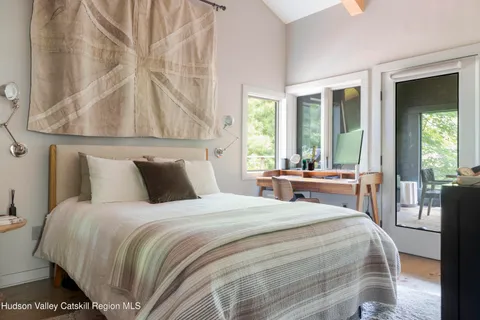 a bedroom with a bed and a large window