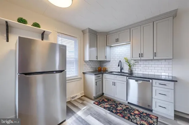 a kitchen with stainless steel appliances granite countertop a refrigerator sink and stove